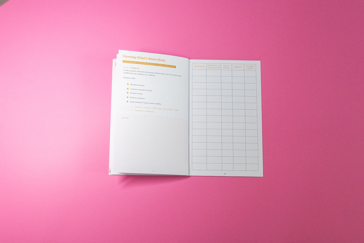 An open booklet or planner page with printed text and a grid chart, placed on a solid pink background.