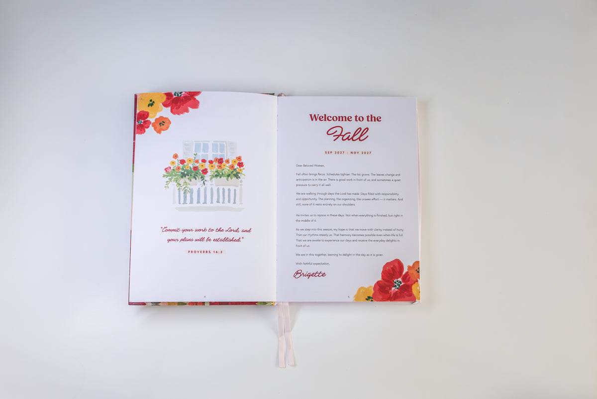 An open printed booklet or invitation spread on a plain white background. The left page shows a floral illustration above a white picket fence with red and orange flowers and a quote.