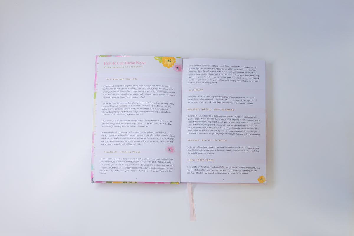 An open book or booklet laid flat on a white background, showing two printed pages with text and small yellow floral illustrations near the top and bottom corners.