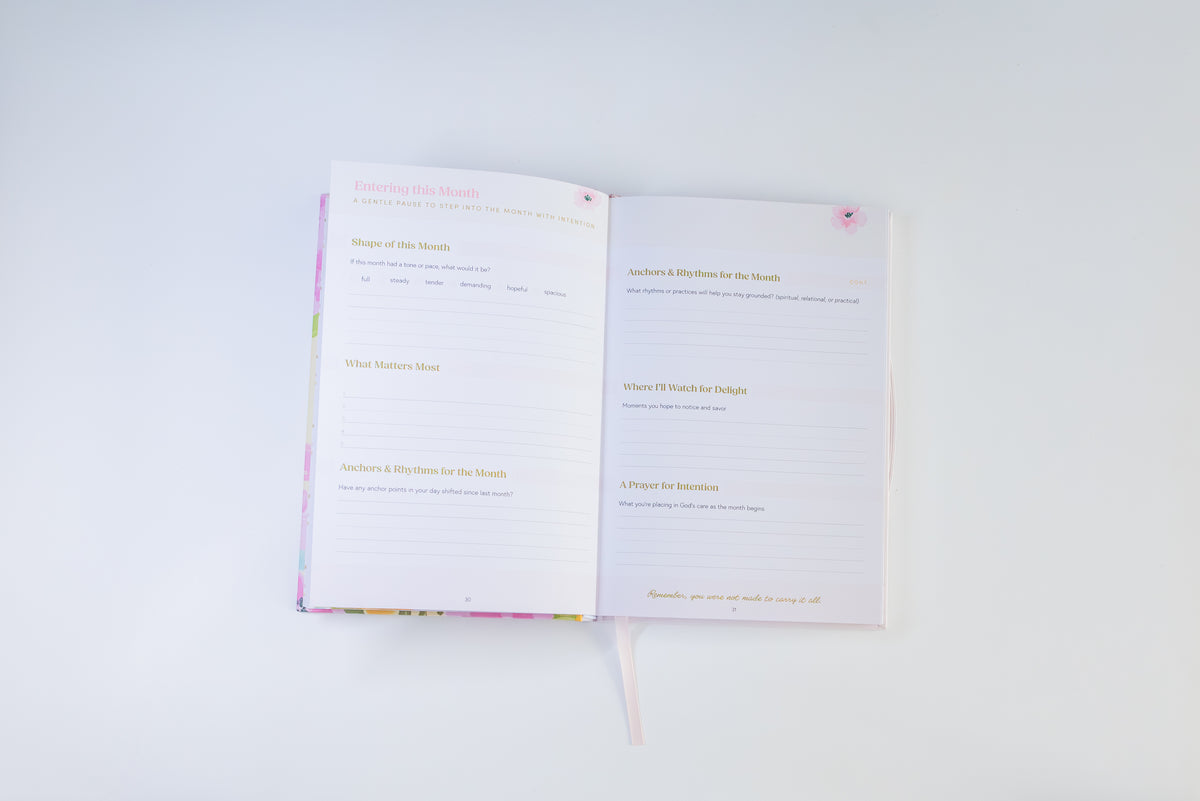 An open notebook or journal with lined pages and gold text, photographed from above on a clean white background.