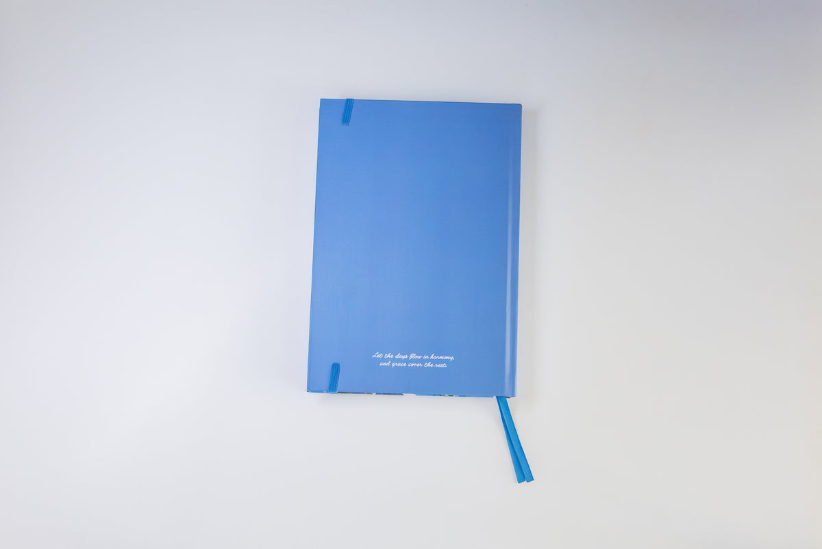 A blue hardcover notebook with a matching blue ribbon bookmark, displayed against a clean white background.